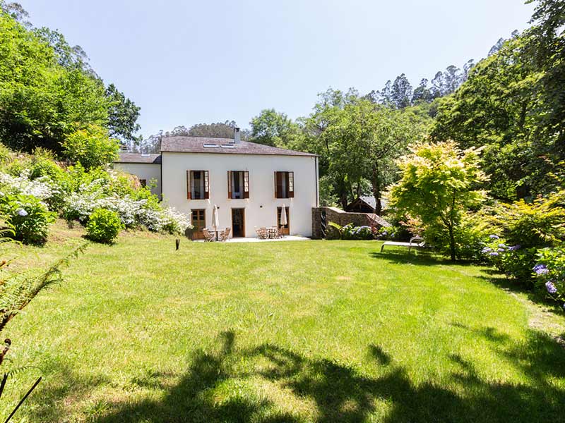 Fachada de la casona con el prado delante